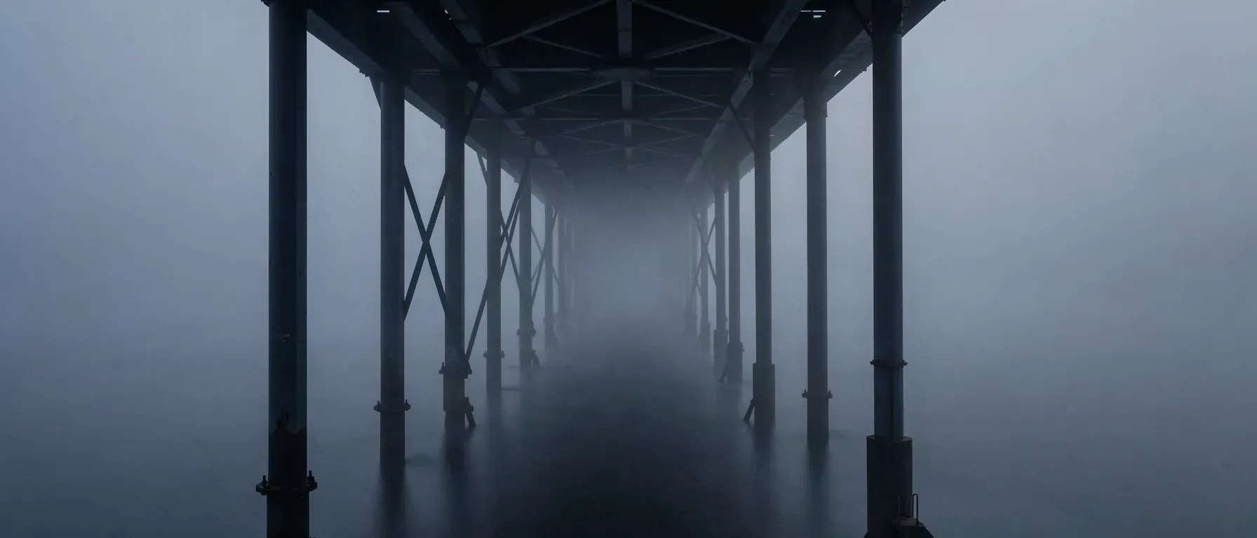 A long steel girder span receding into fog.